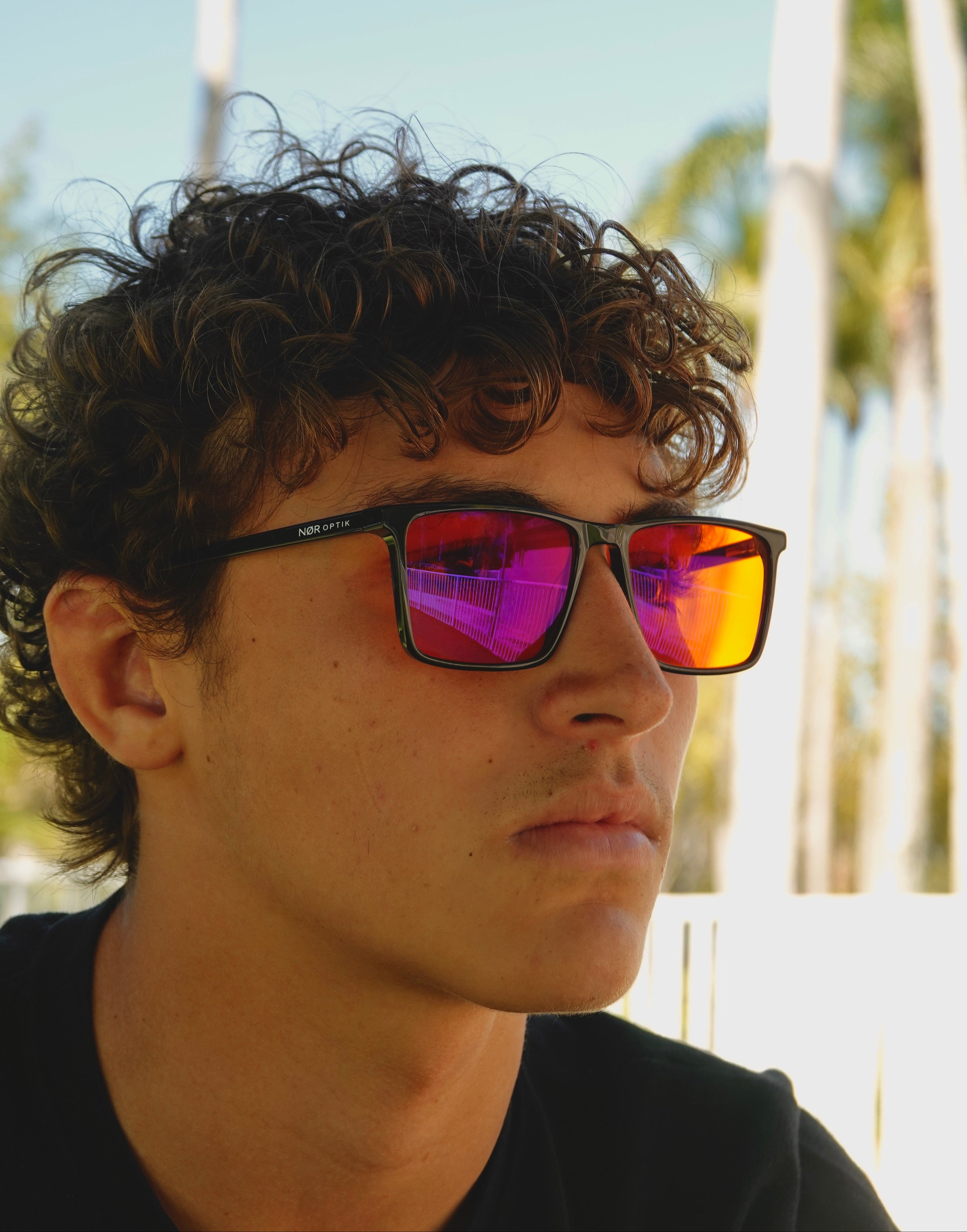 Person wearing colorful sunglasses with a blurred outdoor background